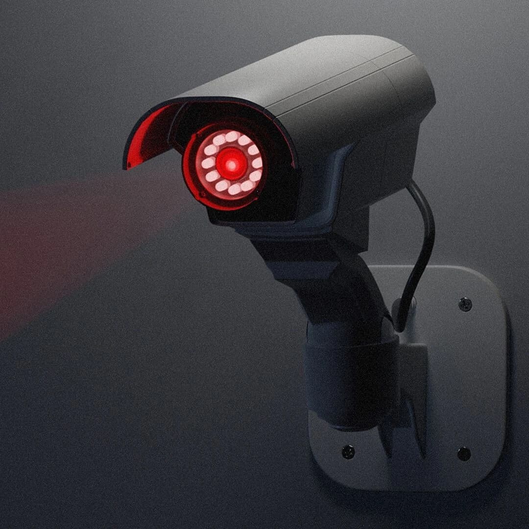 Illustration: a bullet camera mounted on a wall at night, its indicator ring lit red.